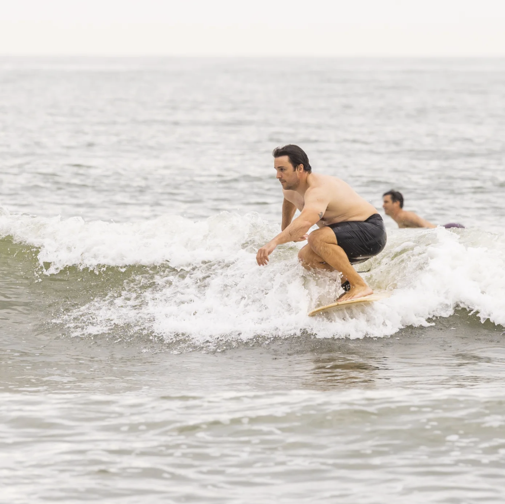 Paul Rice surfeando una tabla de madera